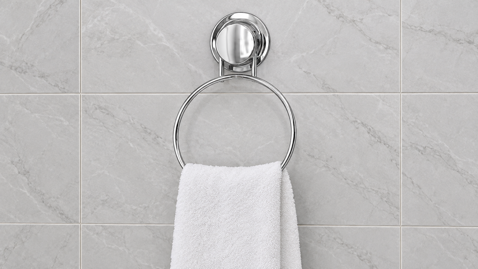 Chrome suction cup towel ring holding a hand towel on smooth bathroom tile.