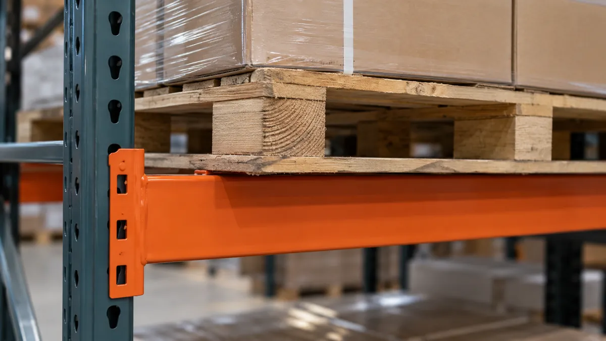 Close-up of a loaded pallet deck and rack beam interface, no weights or numbers