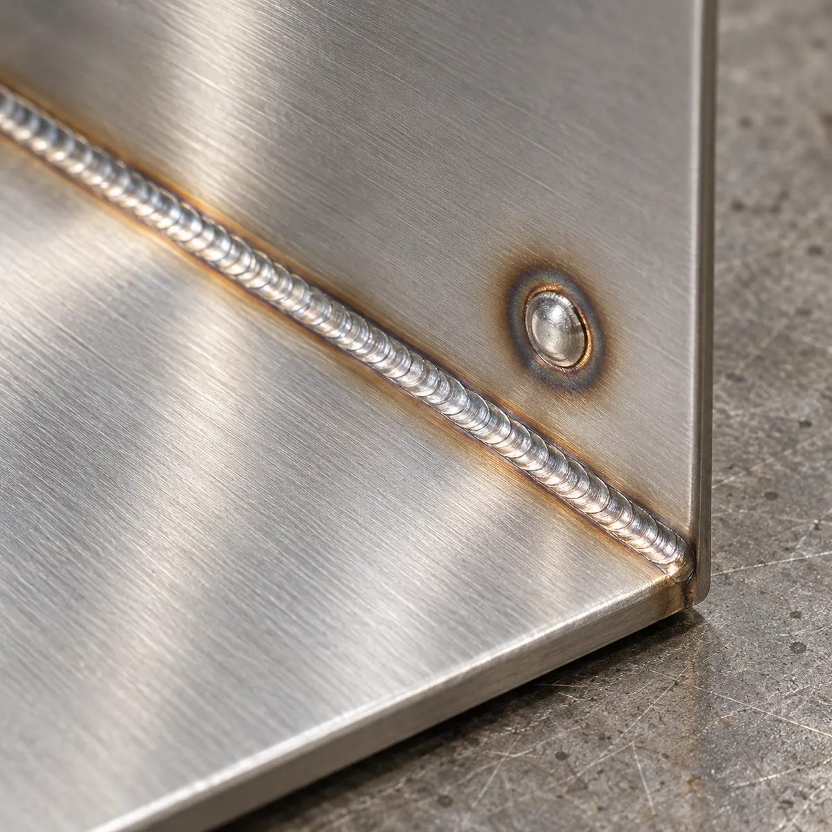 a rectangular metal drip tray with a continuous seam along one edge and a separate row of spaced spot joints in a buyer-focused metal hardware sourcing review