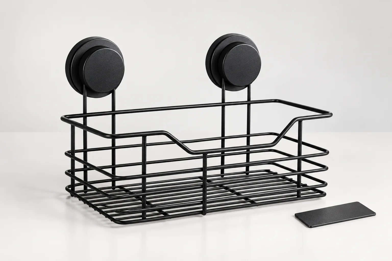 Black two-suction powder-coated wire bathroom basket beside an unmarked coating coupon