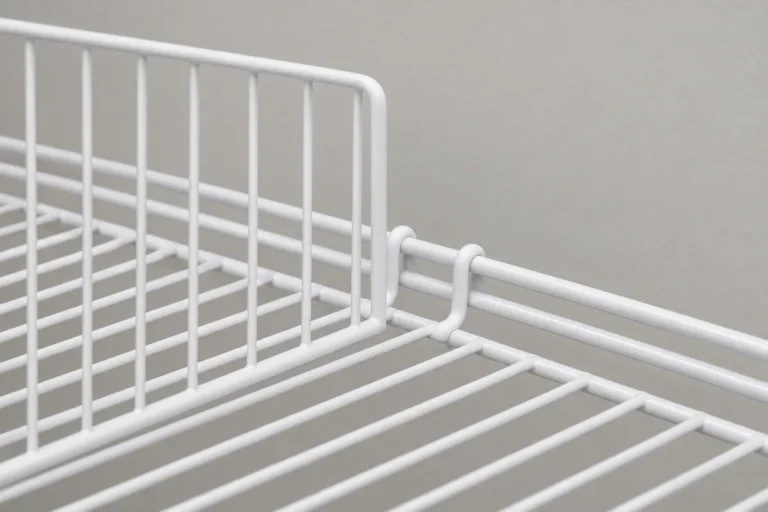 White wire shelf divider with front and rear clips correctly engaged on a matching wire shelf
